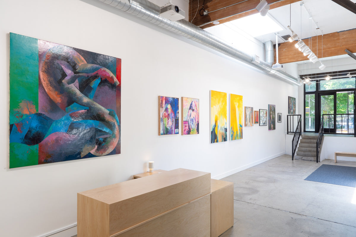 Paintings along the gallery wall, looking toward the entrance